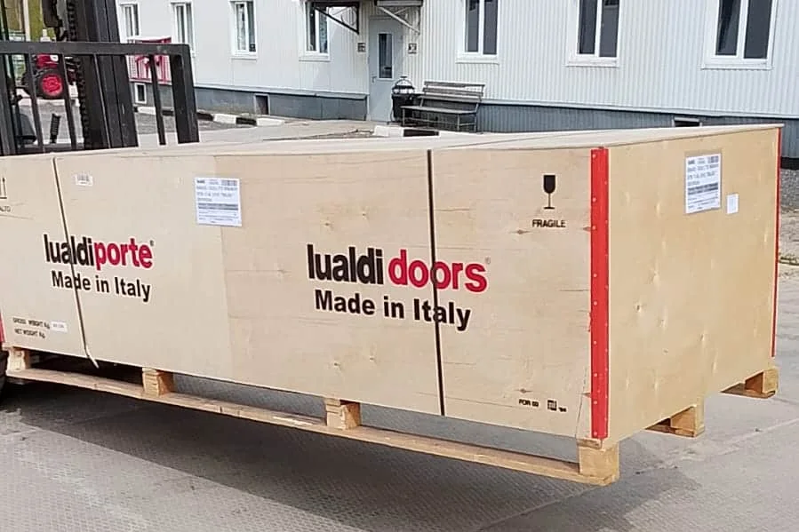 Деревянный ящик с дверями Lualdi, Made in Italy, на поддоне у погрузчика на нашем складе