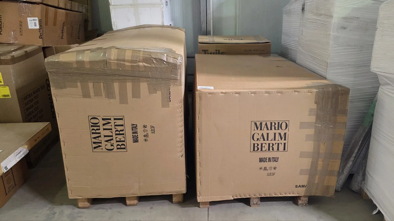 Два дивана Mario Galimberti в картонных коробах на поддонах на складе в Италии, рядом коробки Poliform и Bonaldo